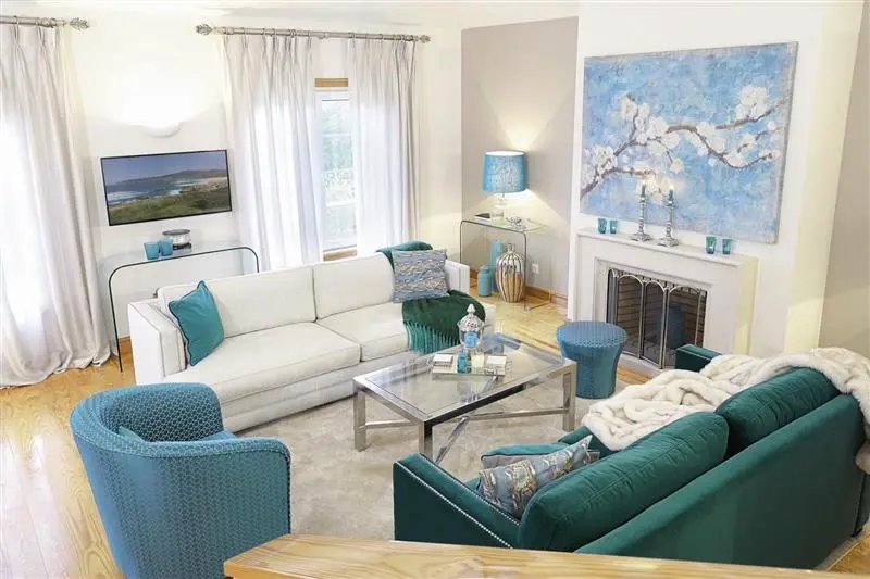 Helles Wohnzimmer mit weißen und türkisfarbenen Sitzmöbeln