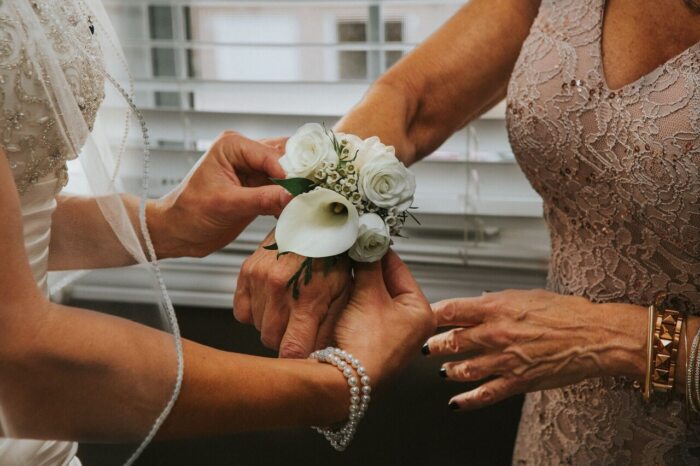 Mutter der Braut trägt Blumengesteck am Handgelenk