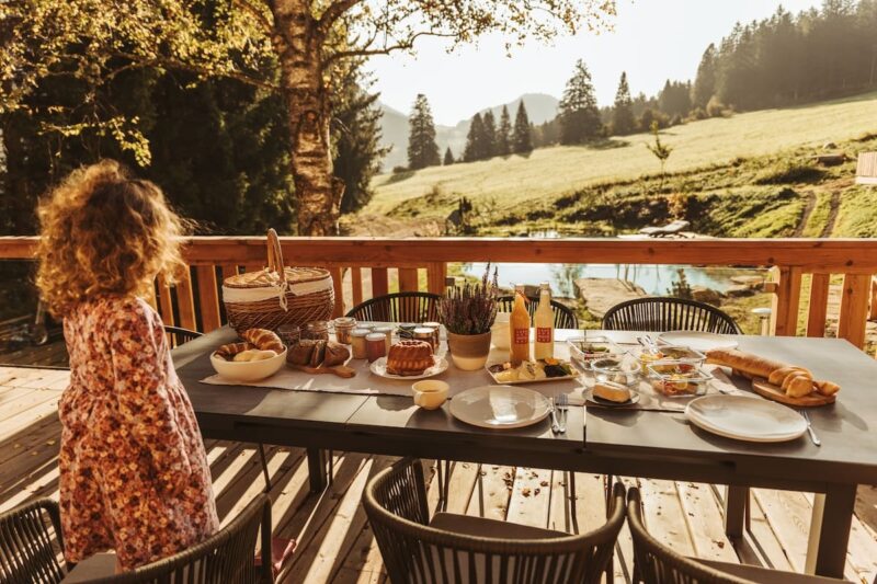 Kleines Mädchen am gedeckten Tisch des Landgut Moserhof