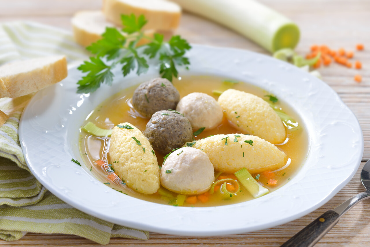 Teller mit Suppe, Kartoffelklößen und Fleischklößchen