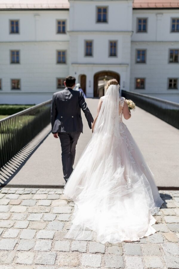 Brautpaar schreitet gemeinsam Richtung Schloss