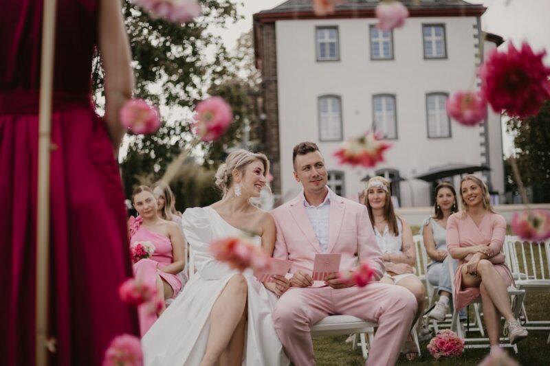Brautpaar sitzt in der pink dekorierten Hochzeitslocation