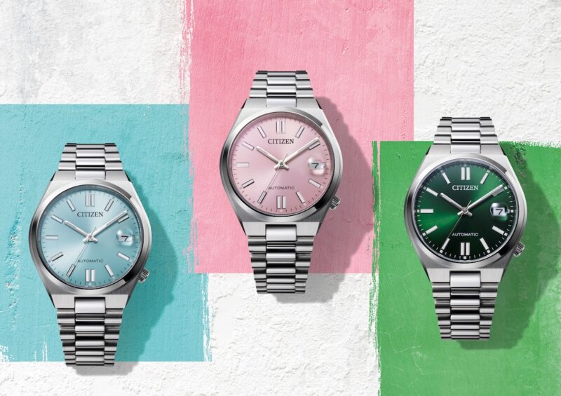 Drei Armbanduhren auf türkisfarbenen, rosa und grünen Flächen