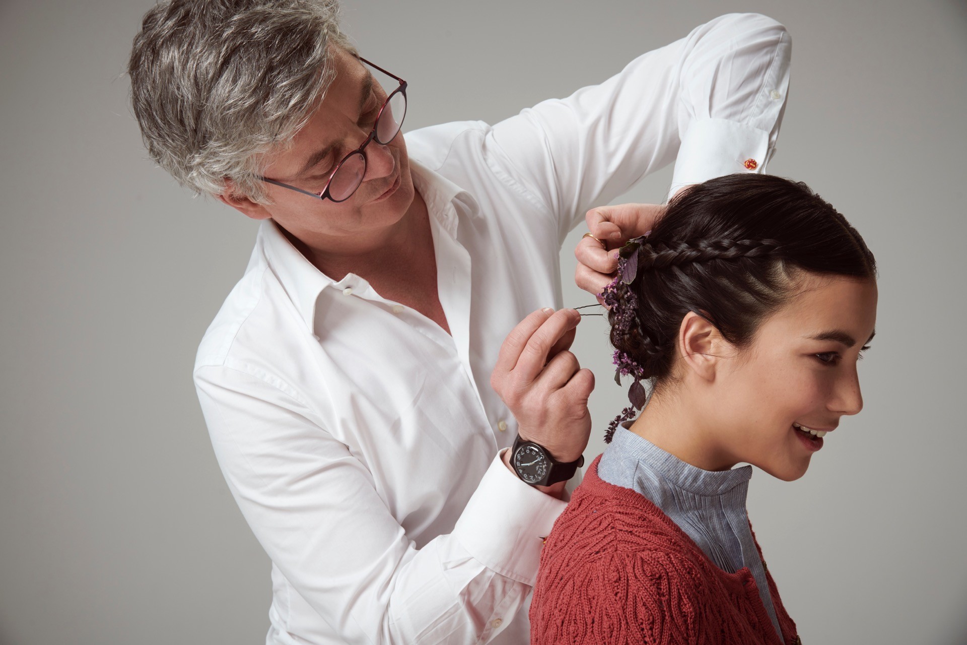Stylist arbeitet an einer geflochtenen Hochsteckfrisur