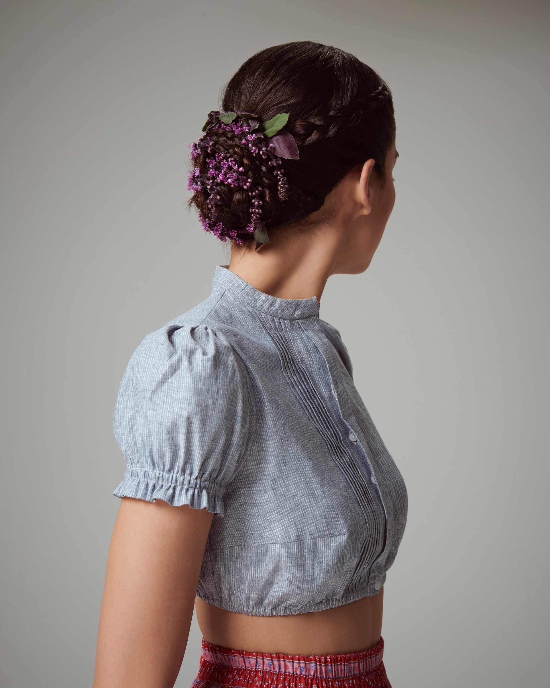 Geflochtene Hochsteckfrisur mit violetten Blüten