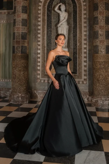 Frau in schwarzem trägerlosem Ballkleid in einem prunkvollen Saal