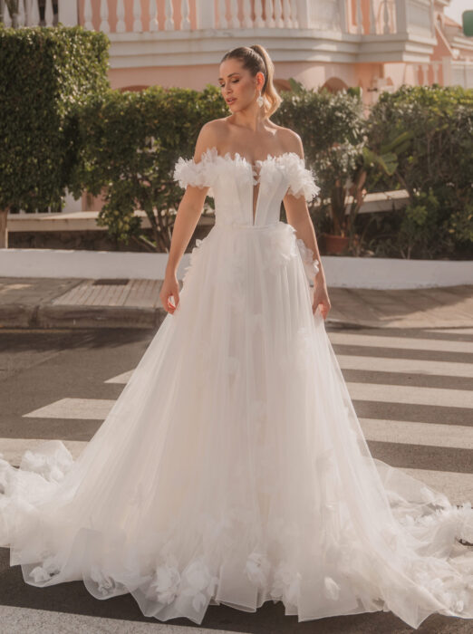 Braut in schulterfreiem Ballkleid mit Rüschen auf einer Straße
