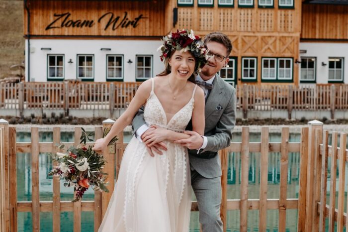 NarzissendorfZloam: Hochzeitspaar posiert vor einer Hütte