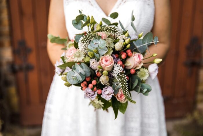 Lockerer bunter Blumenstrauß vor einem weißen Kleid