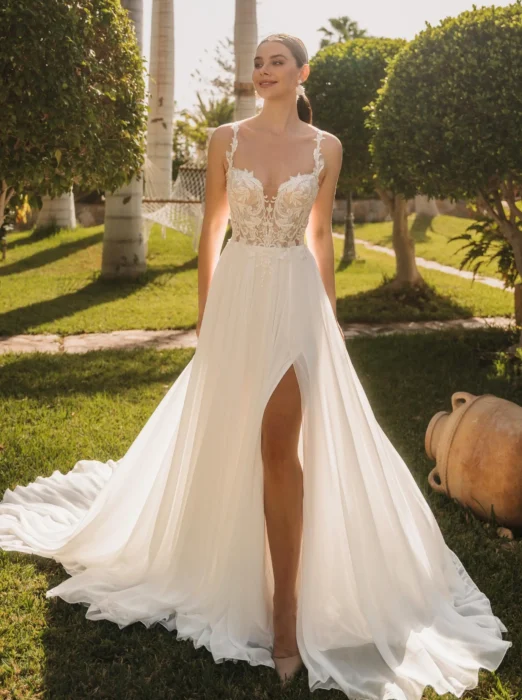Braut in ärmellosem Kleid mit Beinschlitz in einem Garten