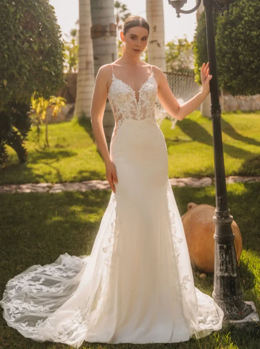 Braut in figurbetontem ärmellosem Spitzenkleid in einem Garten