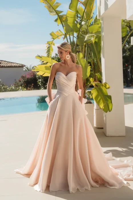 Braut in roséfarbenem A-Linien-Kleid an einem Pool