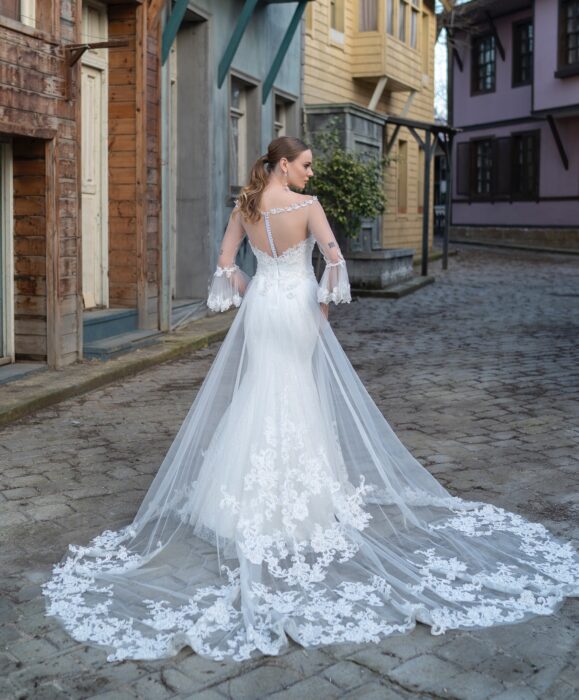 Brautkleid im Fit-and-Flare-Schnitt mit transparentem Überrock, Illusion-Ausschnitt und transparenten Trompetenärmeln mit Spitze von Emine Yildirim, Modell 9004