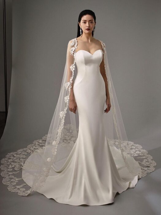 Fit-and-Flare-Brautkleid mit trägerlosem Sweetheart-Ausschnitt und Schleppe sowie separatem Spitzen-Cape von Blue by Enzoani, Modell Monika