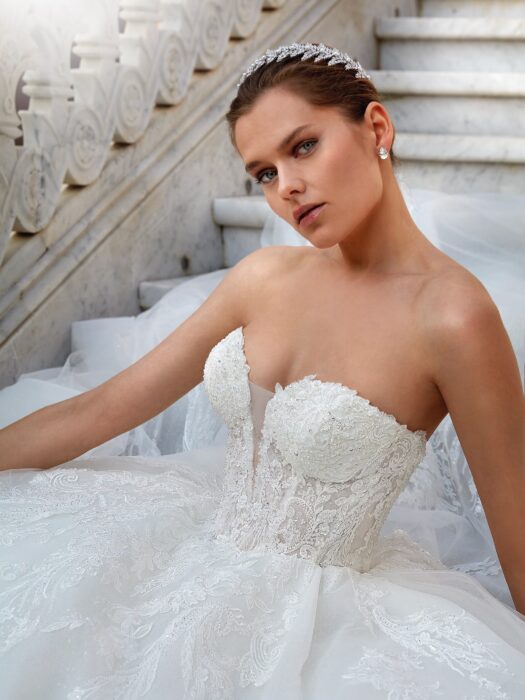 Brautkleid im Prinzessschnitt mit üppigem Rock aus Glitzertüll und Spitzenkorsage mit Sweetheart-Ausschnitt, trägerlos oder mit Offshoulder-Trägern, mit tiefem Rücken und Schleppe von Demetrios, Modll 1210
