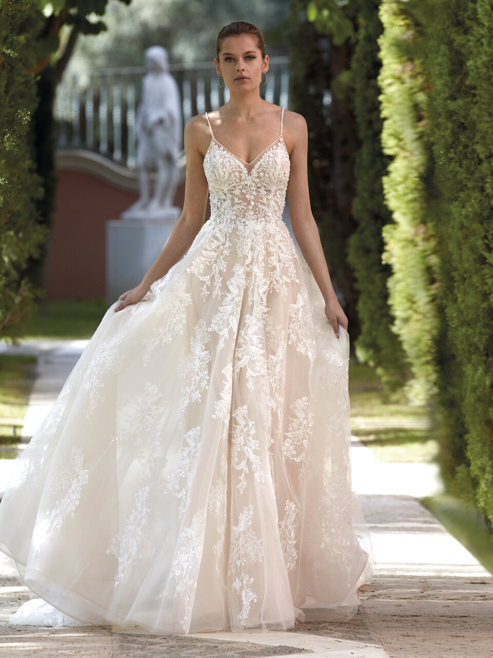 Roséfarbenes Brautkleid im Prinzessschnitt mit 3D-Spitze, Ausschnitt in Herzform, tiefem Rücken, Spaghettiträgern und Spitzenbolero mit Trompetenärmeln von Demetrios, Modell 1212