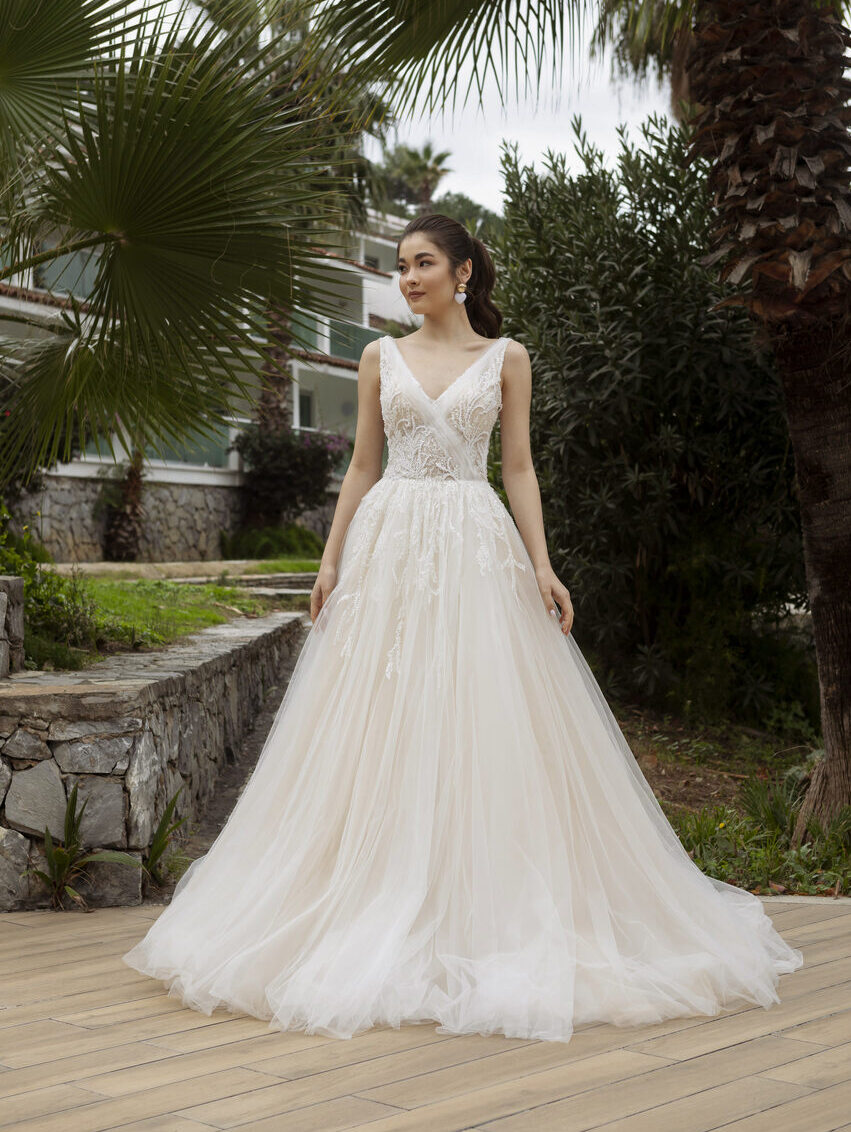 Blush-farbenes Brautkleid iim Prinzessstil mit V-Ausschnit in Wickeloptik, mit Perlen bestickter Spitze und Tüllrock von Emine Yildirim, Modell 5015