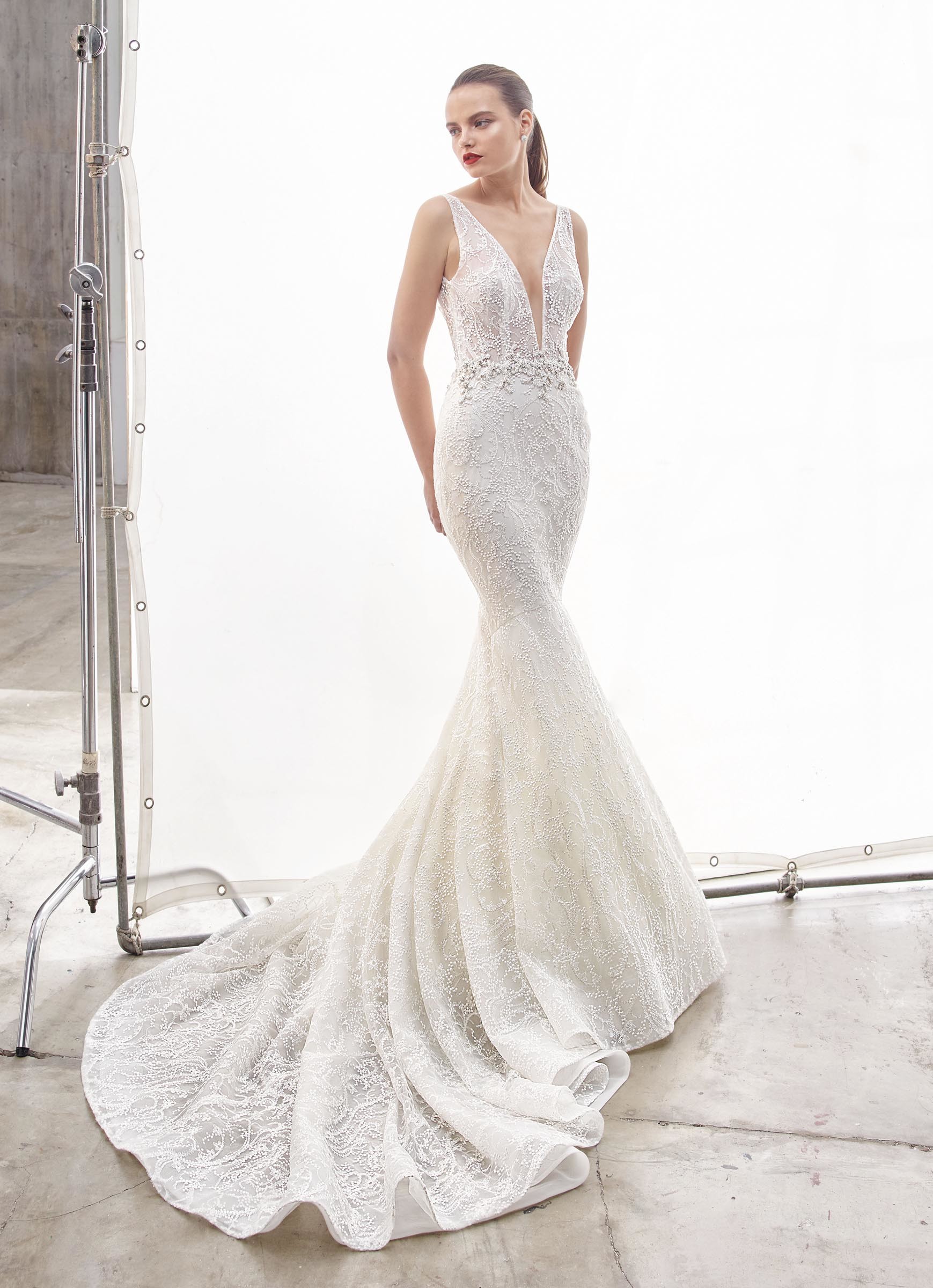 Weißes Brautkleid im Fit-and-Flare-Schnitt mit Spitze, transparentem Top, tiefem V-Ausschnitt, Strassdekoration und Schleppe von Enzoani, Modell North