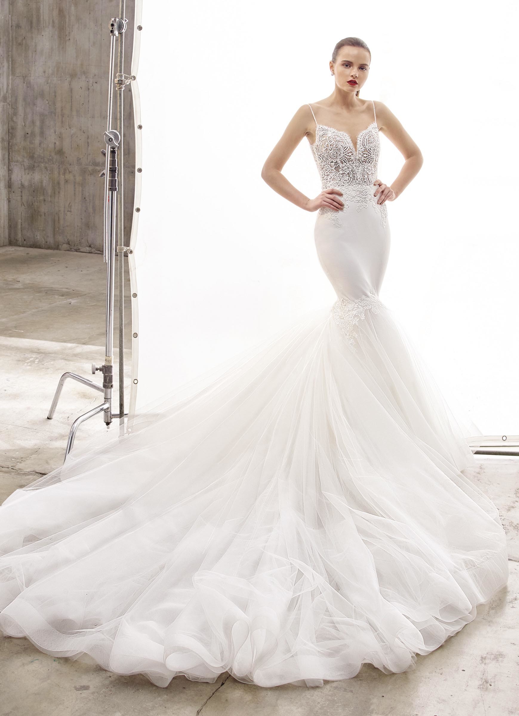 Weißes Brautkleid im Fit-and-Flare-Schnitt mit transparenter Spitzenkorsage, Spaghettiträgern und voluminöser Schleppe von Enzoani, Modell Naya