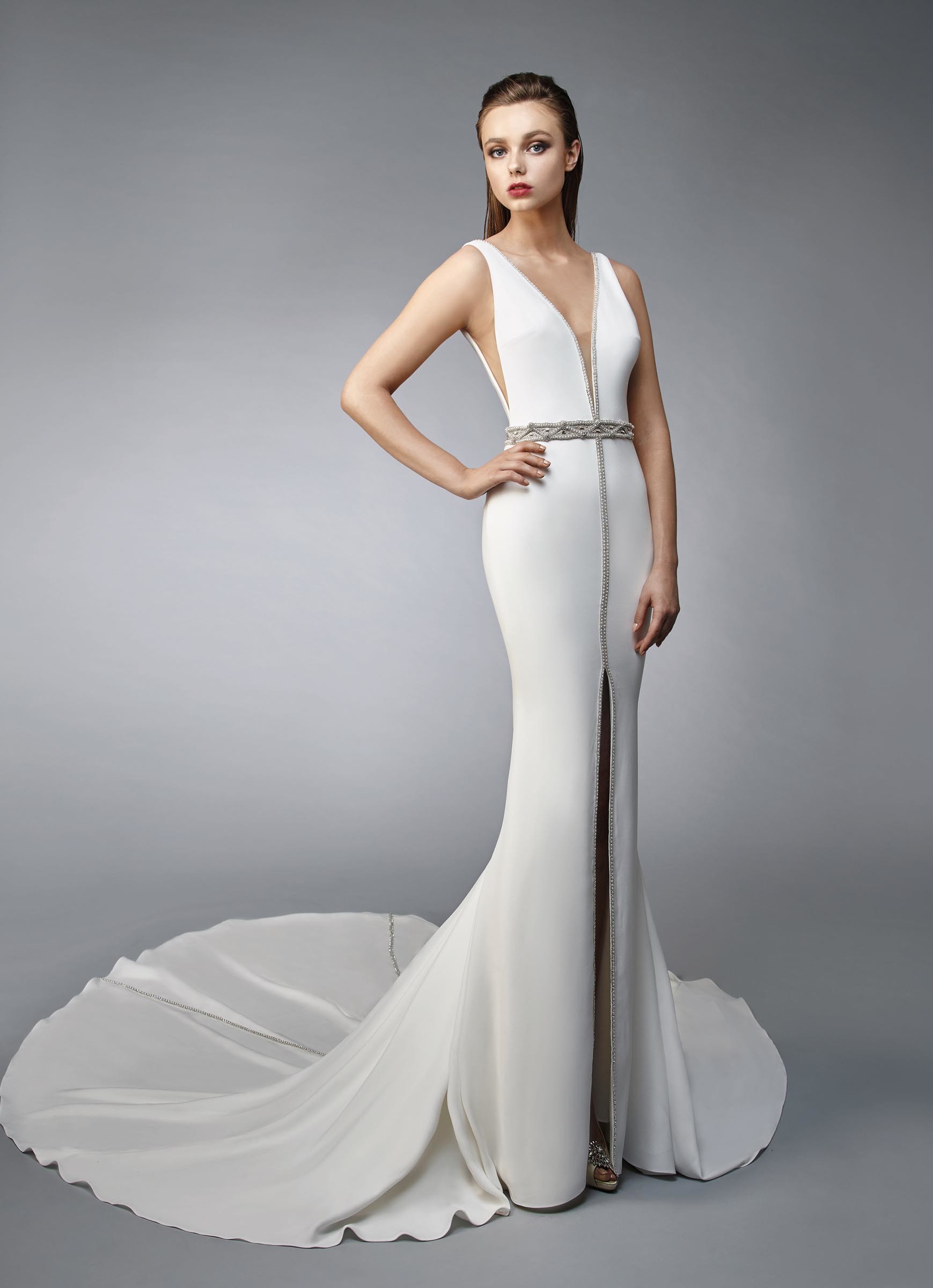 Weißes Brautkleid im Fit-and-Flare-Schnitt mit tiefem V-Ausschnitt, Beinschlitz und Strassdekoration, Gürtel und Schleppe von Enzoani, Modell Norianna
