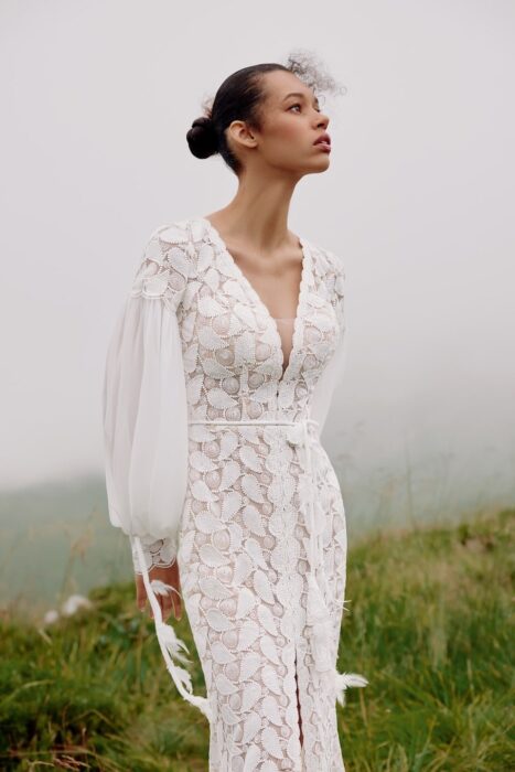 Boho-Brautkleid im Godet-Schnitt mit geschlitztem Rock und Schleppe, Plunge-Ausschnitt und langen Ballonärmeln von Fit-and-Flare-Hochzeitskleid aus Makraméespitze mit Plunge-Ausschnitt, Schmetterlingsärmeln, Rockschlitz und Schleppe von Ariamo Boho, Modell Josephine