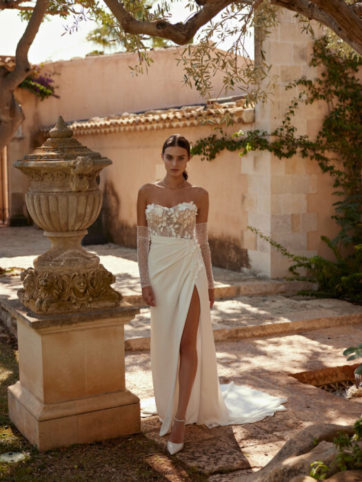 Hochzeitskleid im Fit-and-Flare-Schnitt mit transparenter Spitzencorsage mit schulterfreiem Sweetheart-Ausschnitt, Spitze sowie 3D-Blüten und geschlitztem Crêpe-Rock mit Drapierungen von Le Papillon by Modeca, Modell Elfre