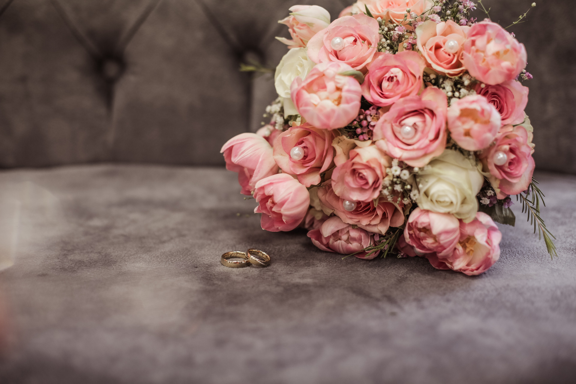 Runder rosafarbener Blumenstrauß auf grauem Untergrund