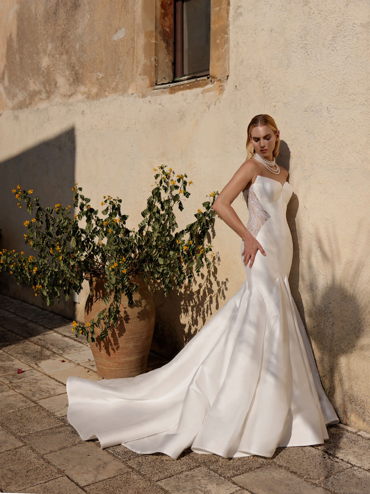 Trägerloses Hochzeitskleid im Fit-and-Flare-Schnitt mit Sweetheart-Ausschnitt, seitlichen transparenten Spitzeneinsätzen und Schleppe von Couture by Modeca, Modell Fosca