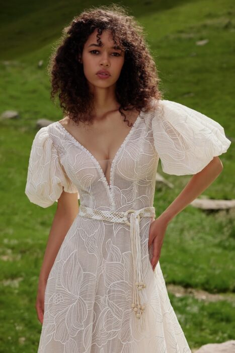 Transparentes, paillettenbesticktes Spitzenhochzeitskleid in A-Linie mit Plunge-Ausschnitt, kurzen Puffärmeln, Gürtel und Schleppe von Ariamo Boho, Modell Etta
