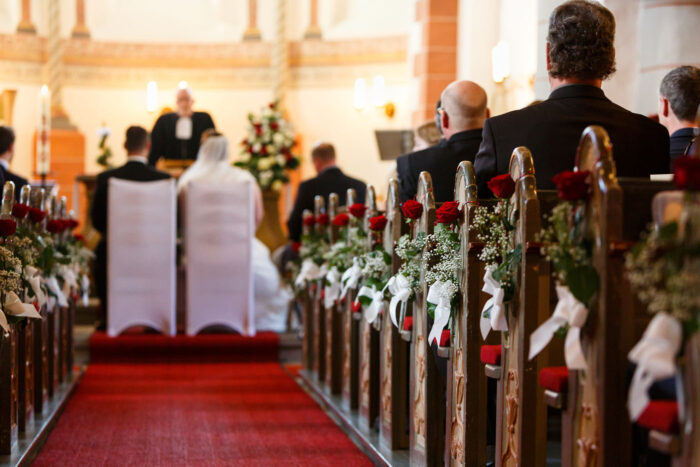 Kirchliche Trauung mit Blick durch den geschmückten Mittelgang
