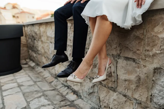Beine eines Brautpaars mit eleganten Hochzeitsschuhen