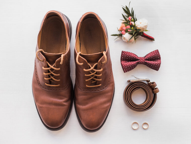 Braune Schnürschuhe mit passendem Gürtel, Fliege, Blumenanstecker und Eheringen